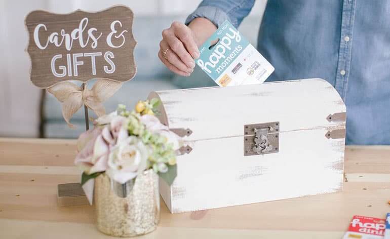 putting gift card into wedding box on gift table