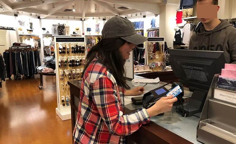 Girl using Happy Card at cash register