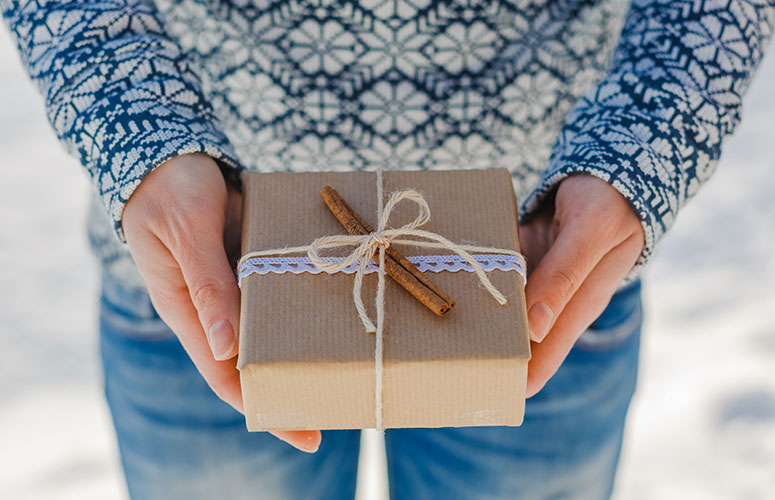 person holding wrapped gift at the door